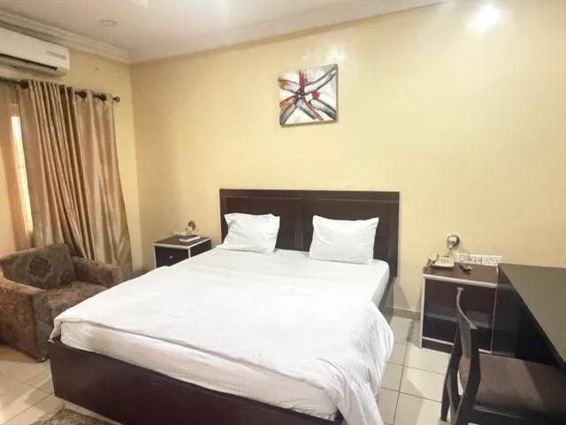 Deluxe king bedroom with soft daylight and layered neutrals